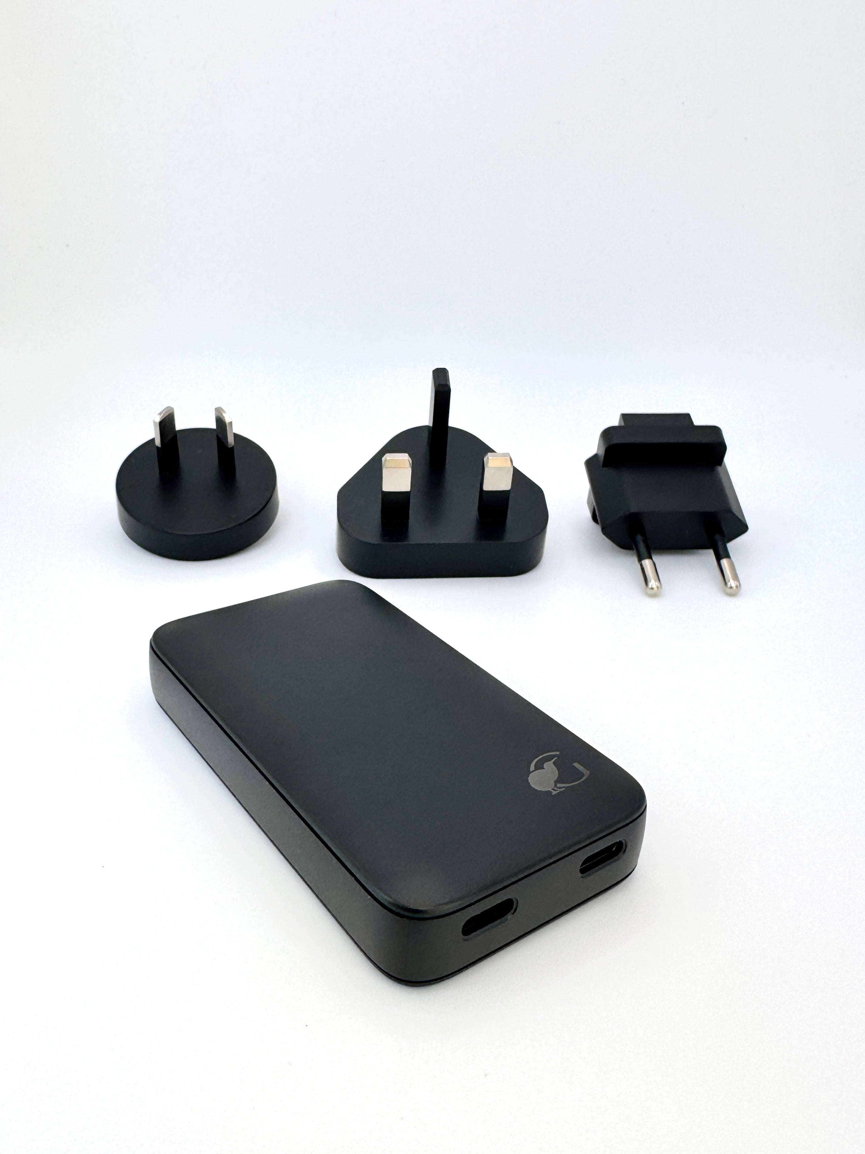 Alt text:
Black portable charger in beige travel pouch with adapters